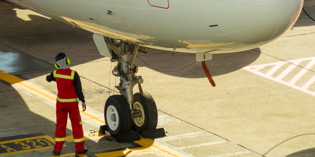 Banner de la sección de Grado Superior en Mantenimiento Aeromecánico con mecánico en pista frente a un avión